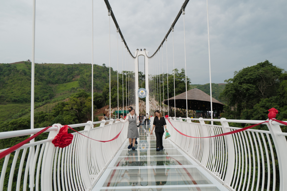 Tourists walking across Bach Long Bridge with panoramic forest views
